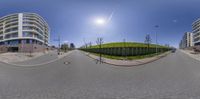 two circular cameras are shown near the bottom of a street near a park with a grass mound in the middle