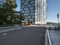 the view from an area that contains many buildings and an overpass with plants, along with trees