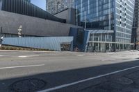 a city street lined with tall buildings and parked cars by a street curb covered in glass