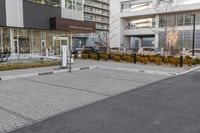 a parking meter in the middle of an empty paved road and surrounded by a city street