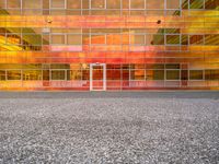 a building that is painted bright orange in the background and yellow with reflection on the windows