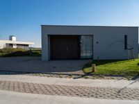 a building sitting on the side of a street next to a road and grass area