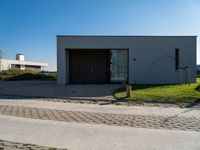 a building sitting on the side of a street next to a road and grass area