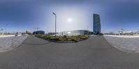 a view of buildings through a fish eye lens at a city park of an intersection