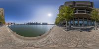 a fisheye lens captures a wide angle view of the buildings, water and street