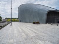 there is a building with a circular roof over the entrance and walkway outside it,