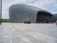 there is a building with a circular roof over the entrance and walkway outside it,