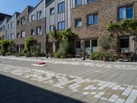 a brick road with various plants and a stuffed red piece of furniture on the side