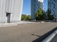 a metal bench sitting next to a building on top of a street in front of tall buildings