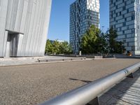 a metal bench sitting next to a building on top of a street in front of tall buildings