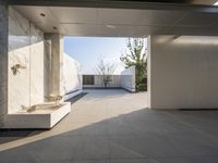 a white bathroom with the tile floor and walls covered in white marble tiles and benches