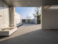 a white bathroom with the tile floor and walls covered in white marble tiles and benches