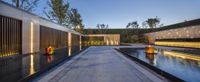 an outdoor pond and a fountain lit up at night, a modern architecture style home design