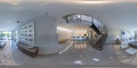 a large living room filled with white furniture and a spiral staircase way going up to it