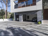 the exterior and landscape of a modern house in los angeles, california with stone and wood