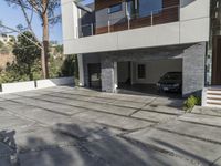 the exterior and landscape of a modern house in los angeles, california with stone and wood