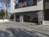 the exterior and landscape of a modern house in los angeles, california with stone and wood