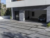 the exterior and landscape of a modern house in los angeles, california with stone and wood