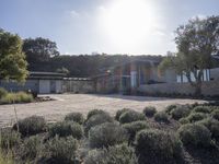 a picture of a very nice house on a hill side by the ocean from a little place near the water