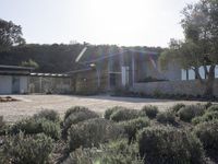 a picture of a very nice house on a hill side by the ocean from a little place near the water