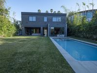 a home that is made out of concrete with a swimming pool on the lawn of the yard