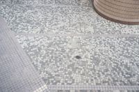 there is a square bathroom floor with a round tiled floor and tiled shower stall in the foreground