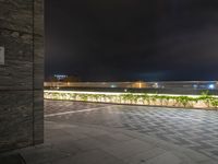 an open parking space on the rooftop at night with lights glowing from inside the building