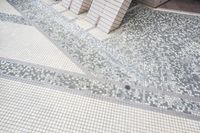 two tile wall in various shapes and colors of white and grey, with one tile floor in square pattern