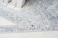 two tile wall in various shapes and colors of white and grey, with one tile floor in square pattern