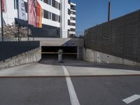 a parking garage with flag hanging on a wall above it and an empty parking space on the right side