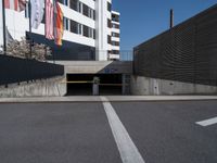 a parking garage with flag hanging on a wall above it and an empty parking space on the right side