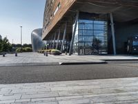 a large building that has a metal structure near it's entrance with windows and doors