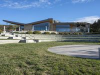 a large house with concrete steps leading to a lawn area outside of the building and stairs are set up next to the grass