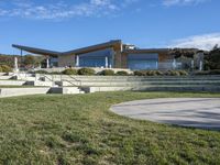 a large house with concrete steps leading to a lawn area outside of the building and stairs are set up next to the grass