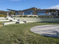 a large house with concrete steps leading to a lawn area outside of the building and stairs are set up next to the grass