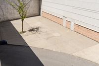 the fire hydrant is on a paved corner of the street near a building in the background