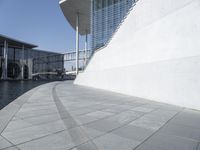 a view of the water's edge of the building while someone in the distance walks along