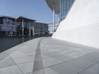 a view of the water's edge of the building while someone in the distance walks along