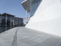 a view of the water's edge of the building while someone in the distance walks along