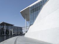 a view of the water's edge of the building while someone in the distance walks along