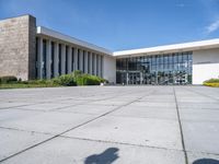 there is a large courtyard with multiple tall windows and benches in front of the building