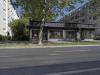 two cars are parked on a busy street in front of a building with trees and grass