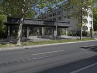 two cars are parked on a busy street in front of a building with trees and grass