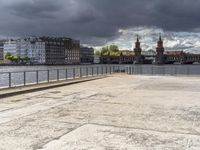 a body of water near some buildings and people on a bench in front of it