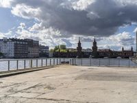 a body of water near some buildings and people on a bench in front of it