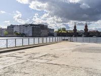 a body of water near some buildings and people on a bench in front of it