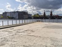 a body of water near some buildings and people on a bench in front of it