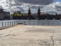 a body of water near some buildings and people on a bench in front of it