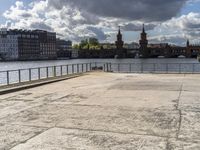 a body of water near some buildings and people on a bench in front of it