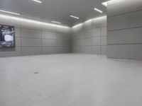 a white floor has tile and lights lit by recesses in an empty room on the wall